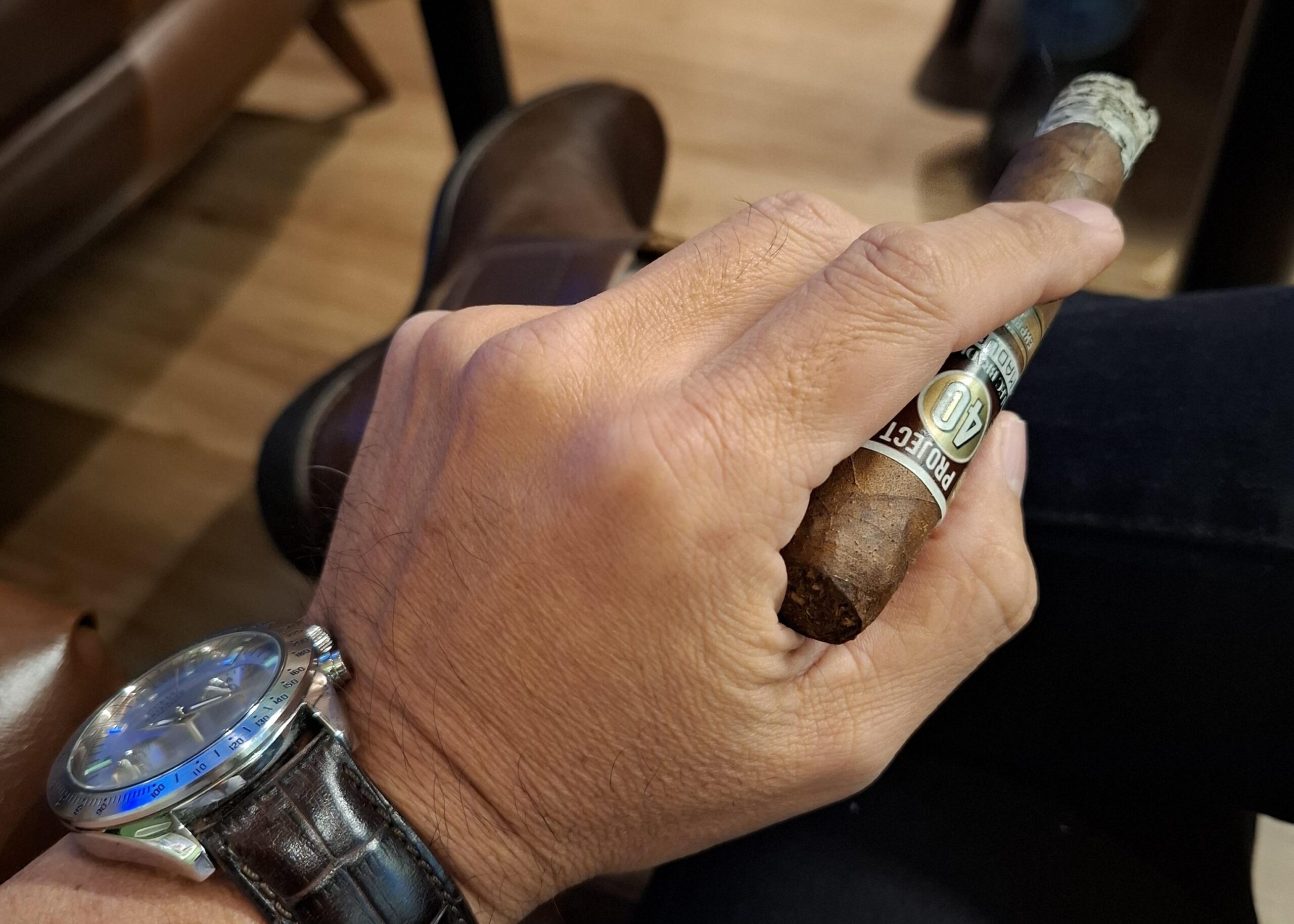 Homem aprecia um charuto em um momento de contemplação, refletindo sobre o tempo, a vida e a importância de viver cada instante com presença.